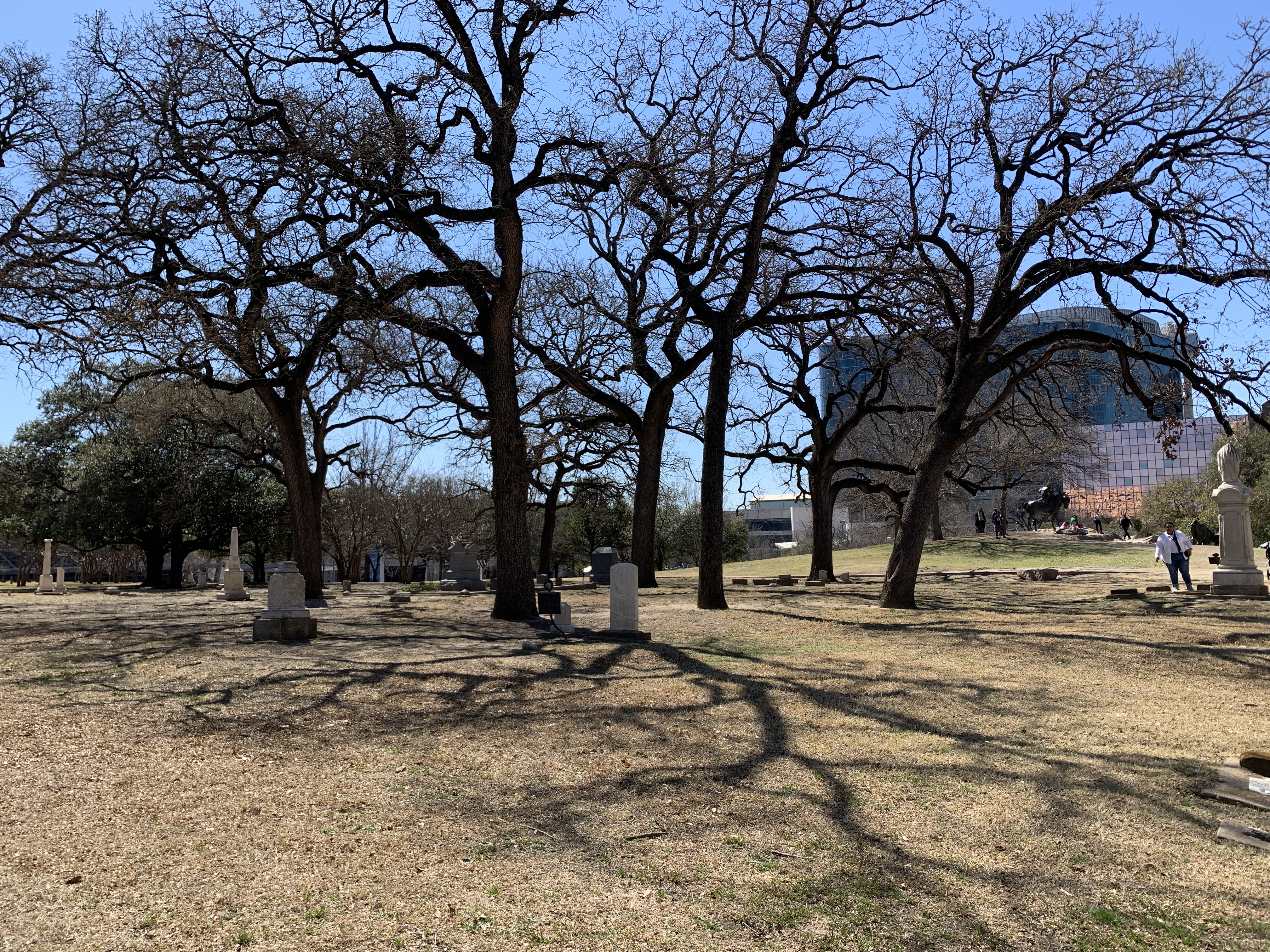 Pioneer Park Cemetery headstones beneath the Convention Center District skyline